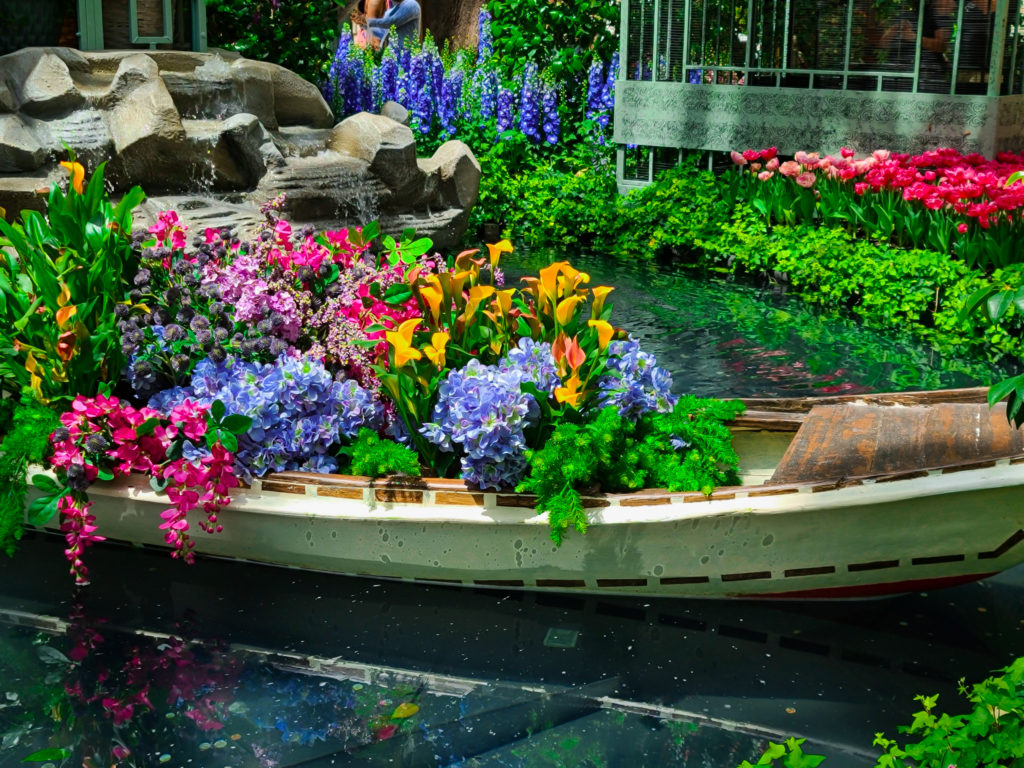 A boat filled with flowers floating in the Bellagio's Conservatory. 