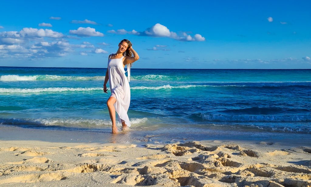 Walking into the ocean in a white dress.