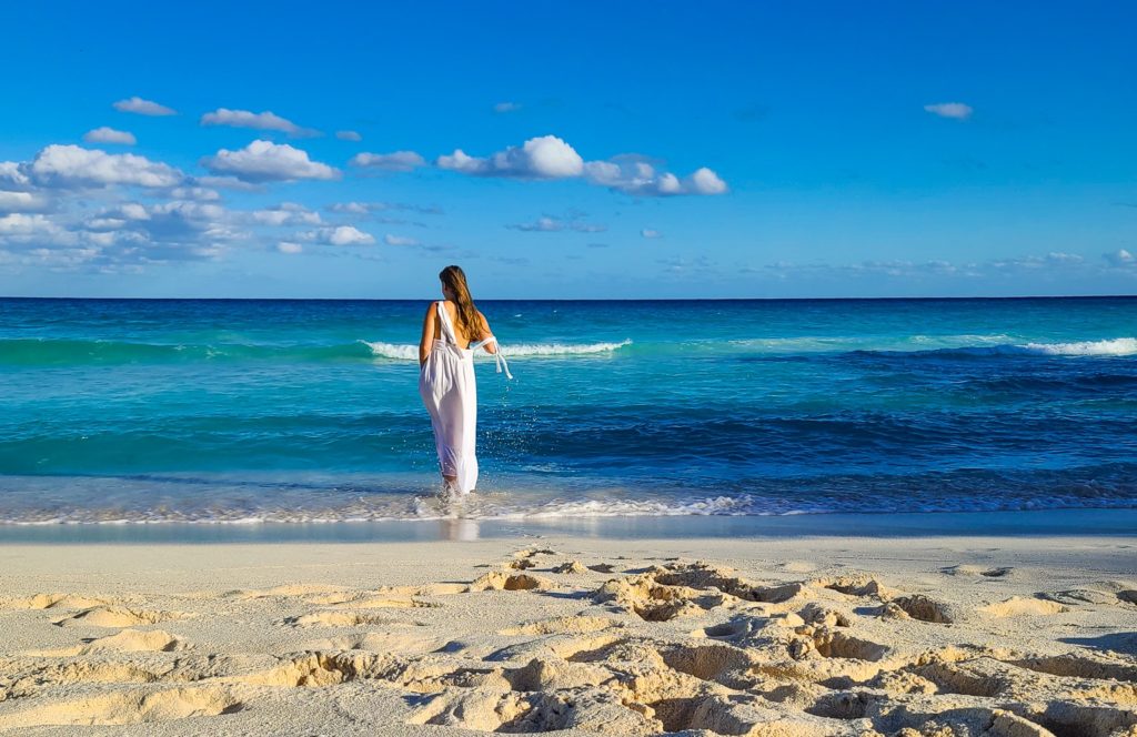 Walking into the ocean in a white dress.